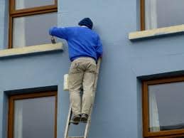 man painting a building