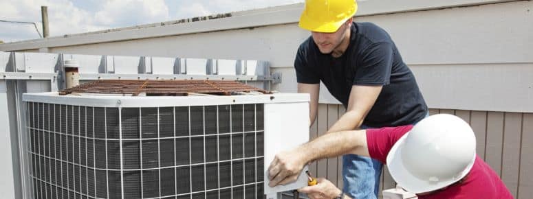 men repairing an AC unit